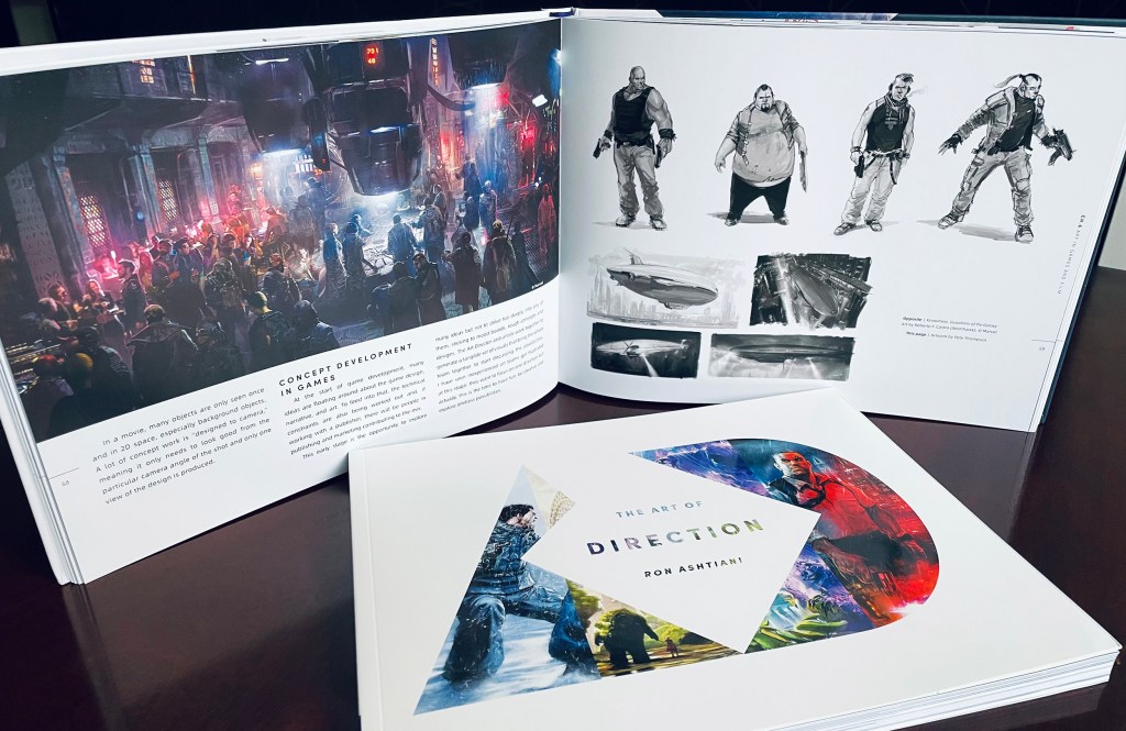 Spread of pages from The Art of Direction, featuring a cyberpunk scene on the left and futuristic characters on the right. Another closed copy of the book sits in front of this spread.